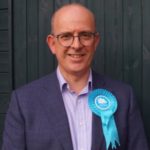 Andy Coles wearing a Conservative Party rosette