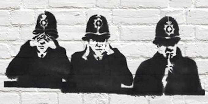 Spraypain stencil of 3 British police in 'brass monkeys' pose